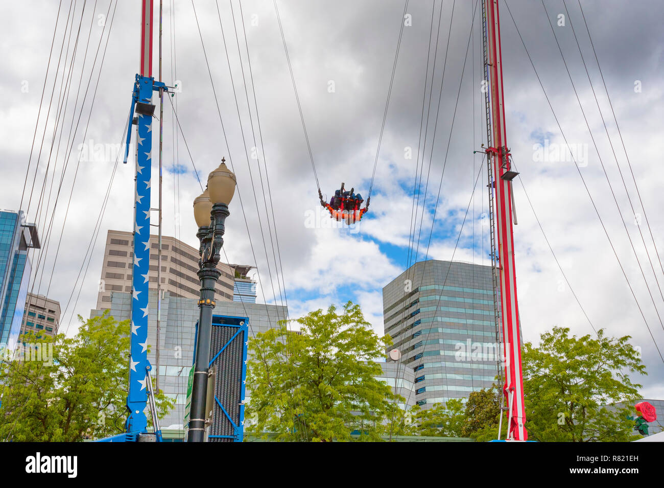 Portland, Oregon, USA - Le 29 mai 2010 : un carnaval comme bungie ride shoots riders très haut dans le ciel nuageux le long Tom McCall Water Front Park. Banque D'Images