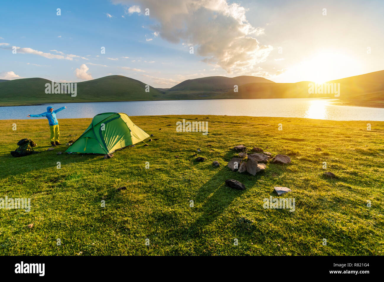 Camping en tente fille sauvage par lac Akna, montagnes Geghama volcano, Arménie Banque D'Images