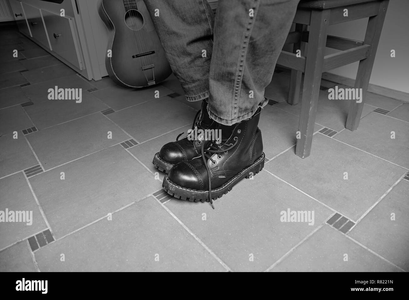 Rock and Roll concept. Bottes noires et guitare classique. Image en noir et blanc Banque D'Images