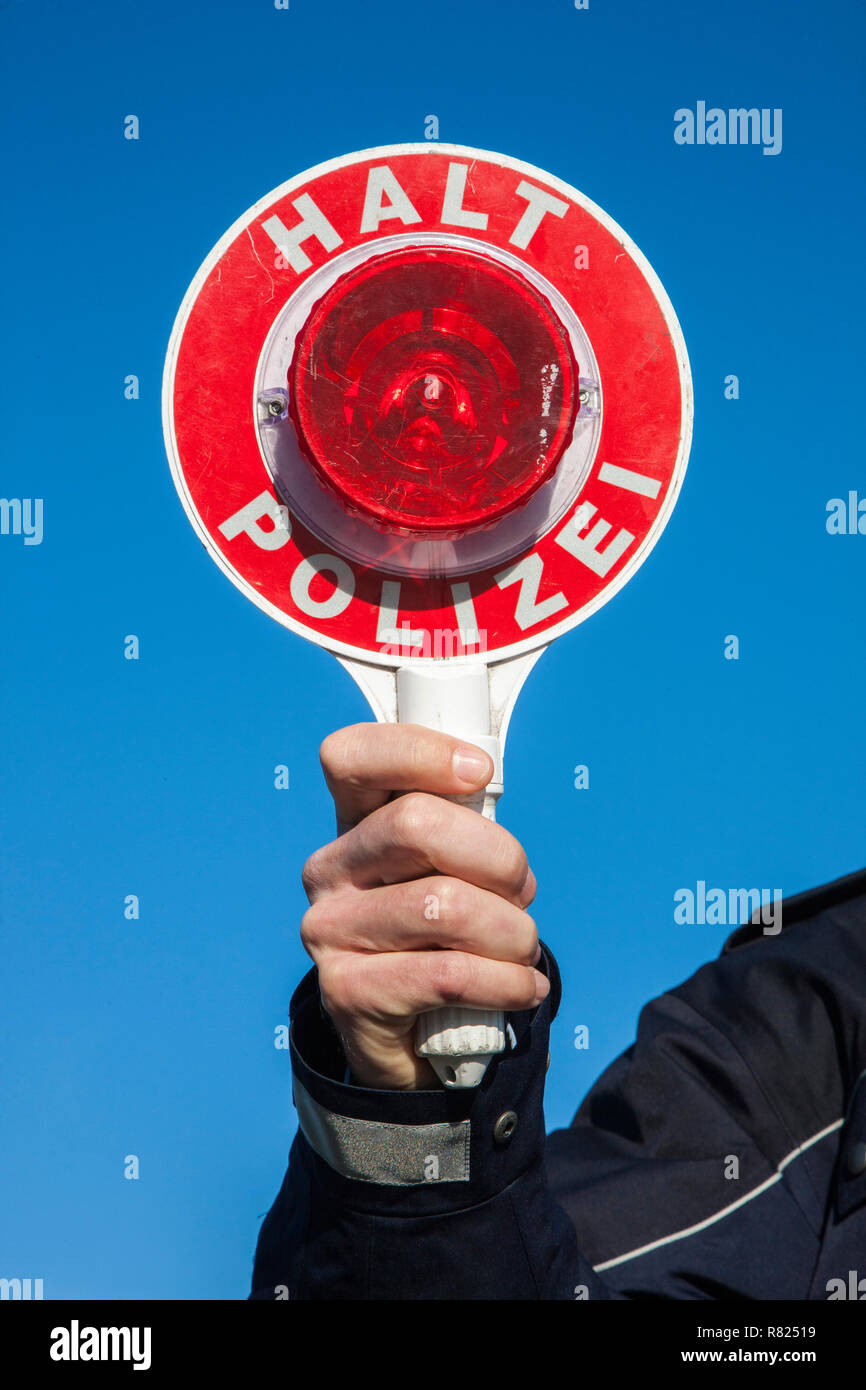 Policier tenant un disque de signalisation de police, Allemagne Banque D'Images