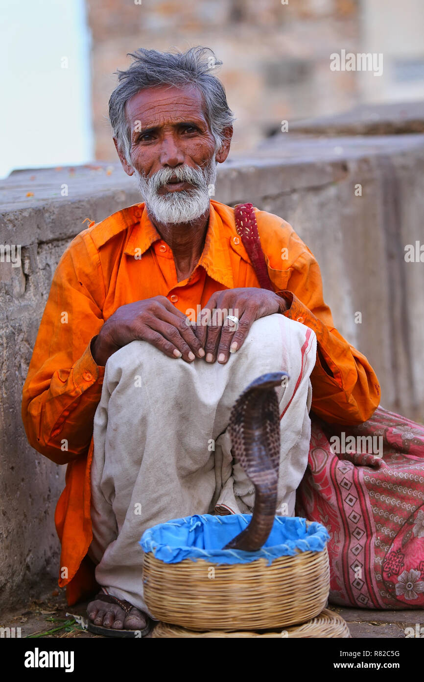 Charmeur de serpent local assis dans la rue de Jaipur, Inde. Jaipur est la capitale et la plus grande ville de l'état indien du Rajasthan. Banque D'Images