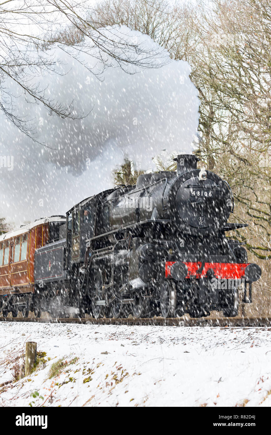 Locomotive à vapeur et tablier rétro britanniques approchant de la tête en cas de chute de neige. Train à vapeur Puffing (avant) en action, ligne ferroviaire du patrimoine de Severn Valley. Banque D'Images