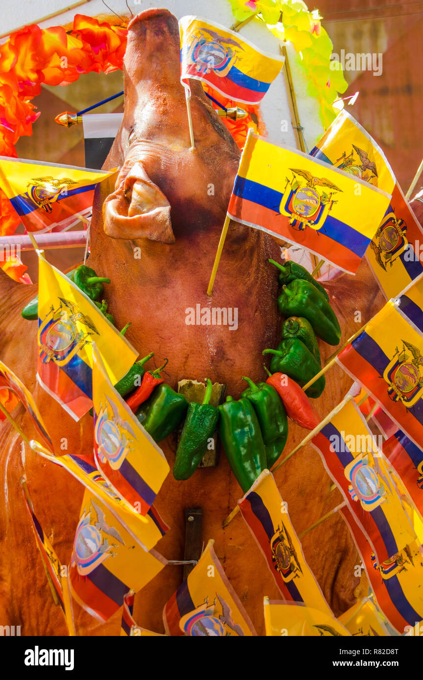 Voir ci-dessus de porc roaste corps avec drapeaux équatoriens autour du corps et des poivrons magnifiques autour du cou - Spécialité cuisine équatorienne Saquisili marché. C'est un mets populaire en Equateur Banque D'Images