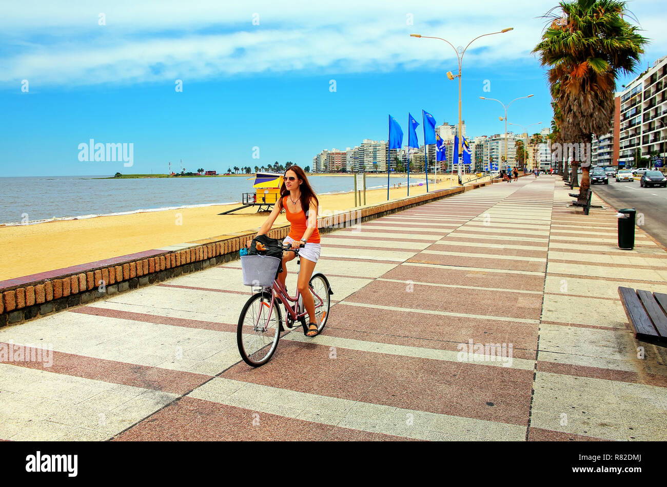 Femme cycliste sur le boulevard le long de la plage de Pocitos à Montevideo, Uruguay. Montevideo est la capitale et la plus grande ville de l'Uruguay Banque D'Images