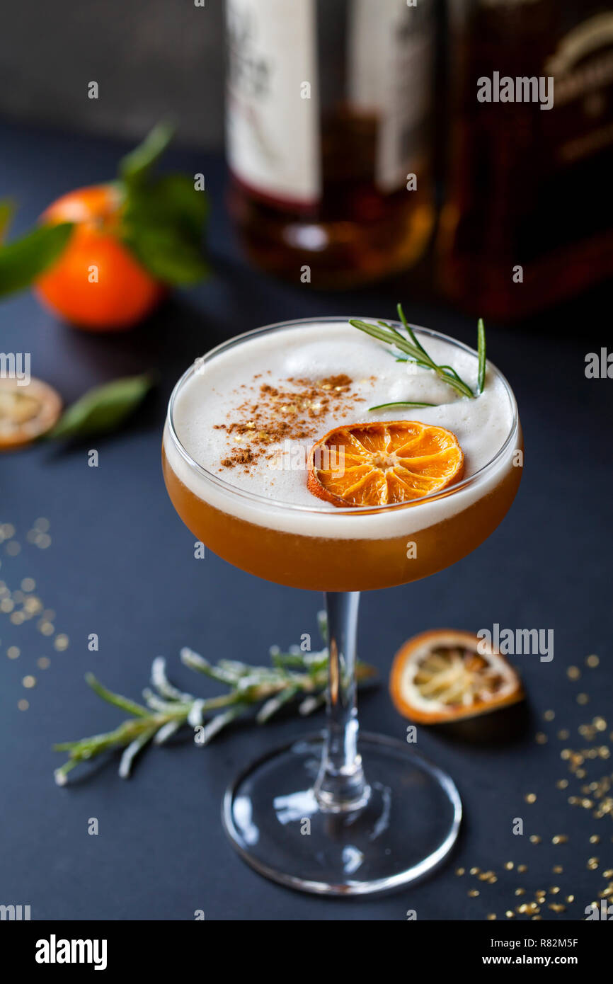 Cocktail de Noël d'amaretto sour avec clémentine déshydraté et romarin Banque D'Images