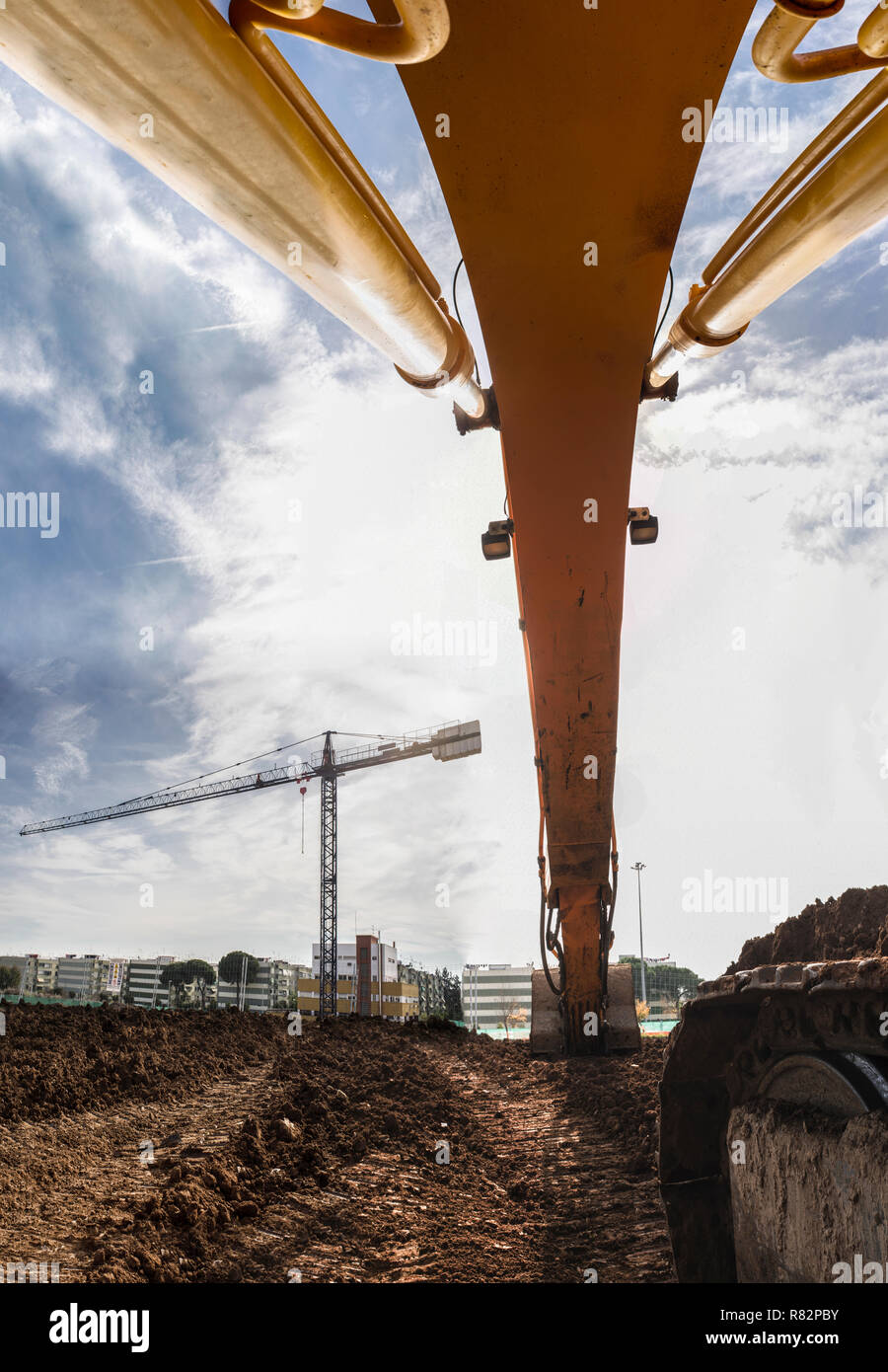 Voir l'excavatrice terrassement sous la rampe au niveau du site de construction. Arrière-plan de machines de construction Banque D'Images