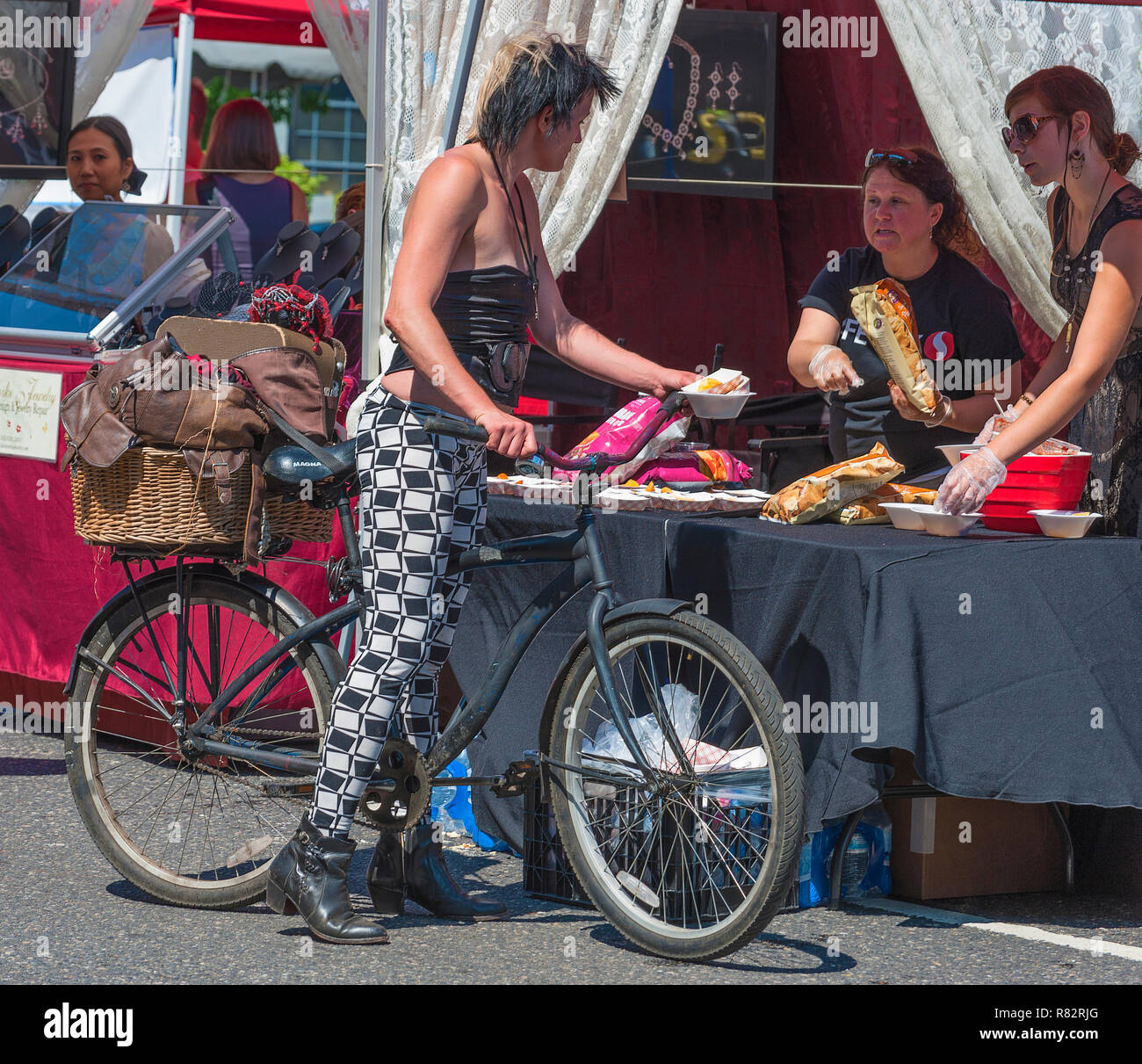 Portland, Oregon, USA - Août 17,2014 : Hawthorn Street événement communautaire annuel. Une dame sur un vélo s'arrête d'acheter des aliments dans un vender. Banque D'Images