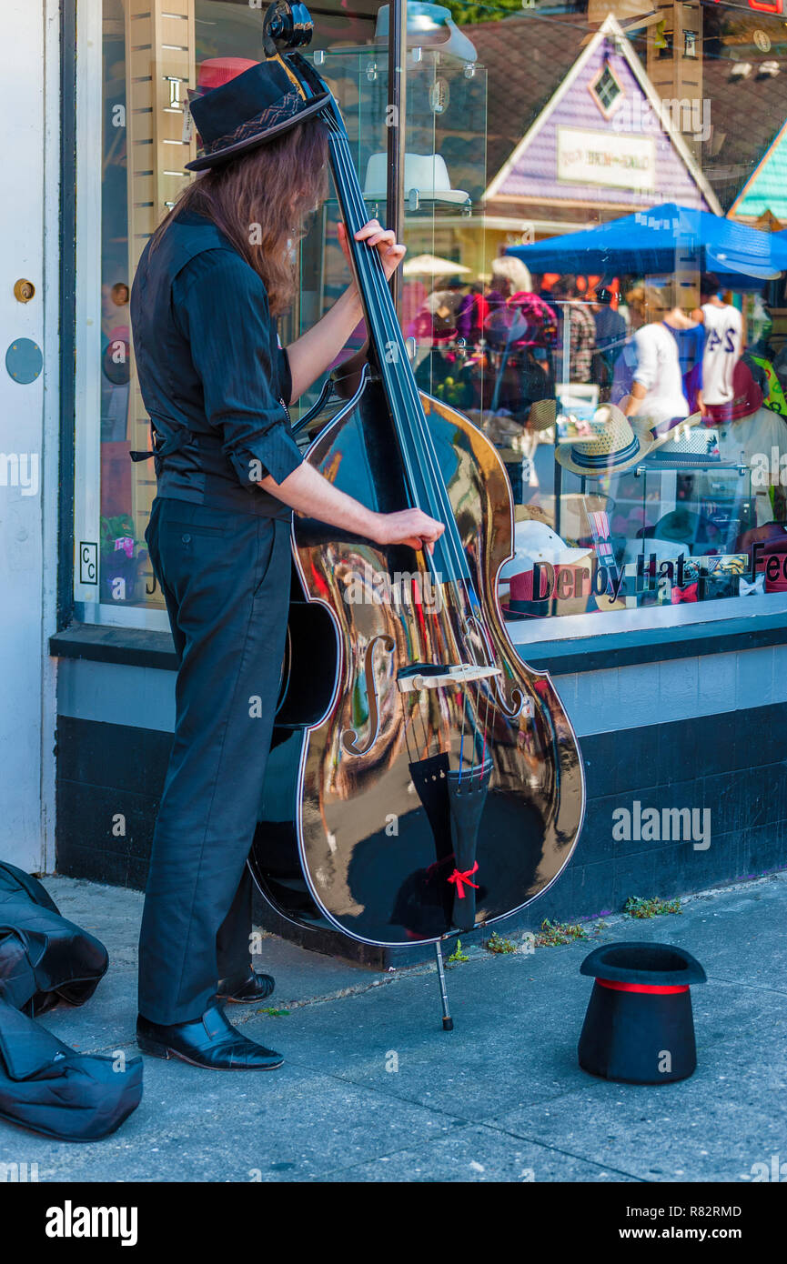 Portland, Oregon, USA - Août 17,2014 : Hawthorn Street événement communautaire annuel. Un musicien de rue joue un bass vêtus de noir un top hat pour collecti Banque D'Images