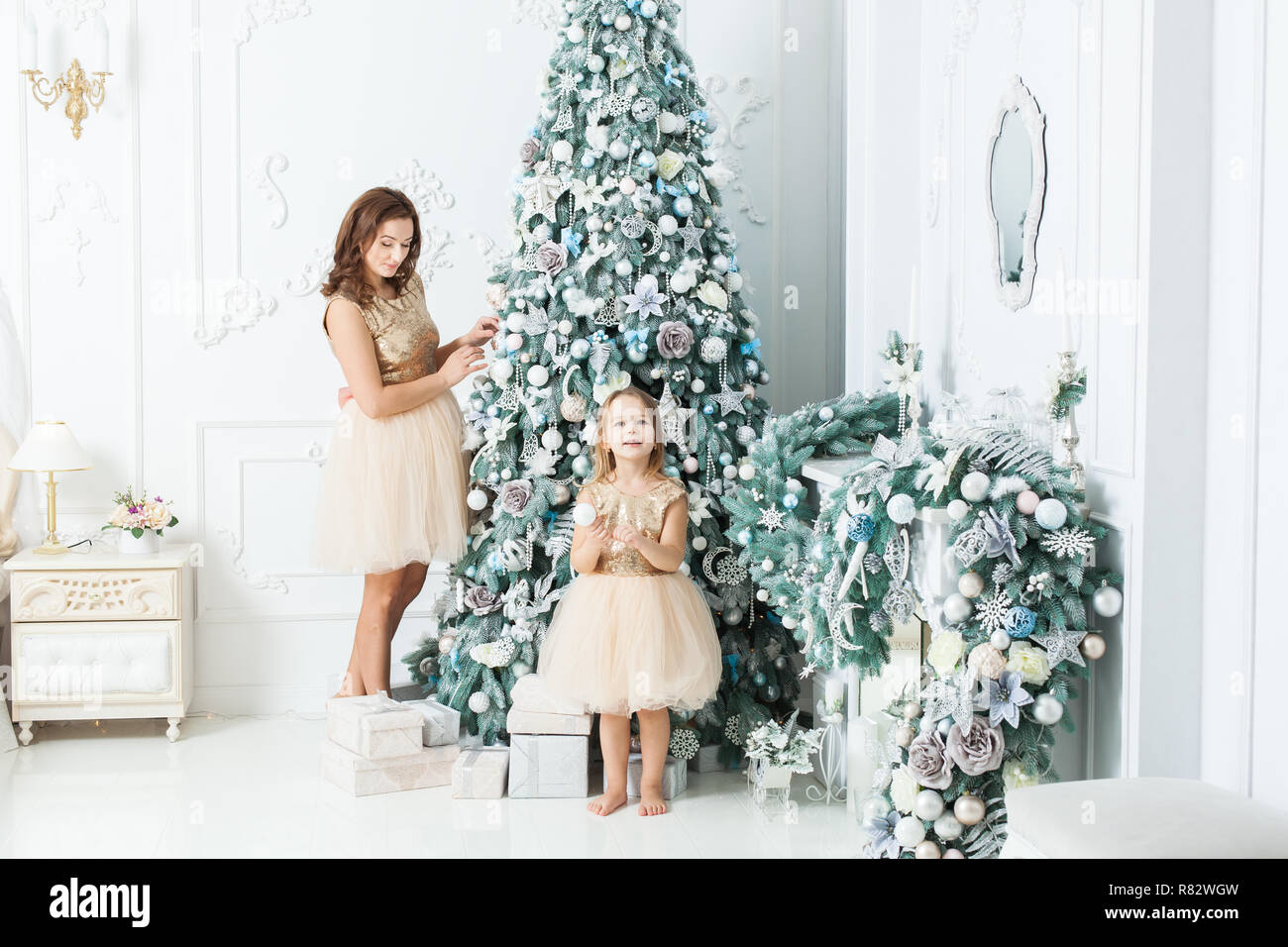 Belle jeune femme avec sa fille décorer l'arbre de Noël. Banque D'Images