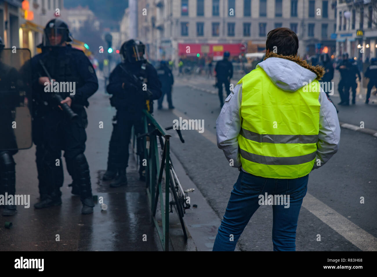 La police antiémeutes et jaune de vestes (gilets jaunes) manifestants contre la taxe sur les carburants, le gouvernement, et le président français Macron. Lyon, France. Banque D'Images