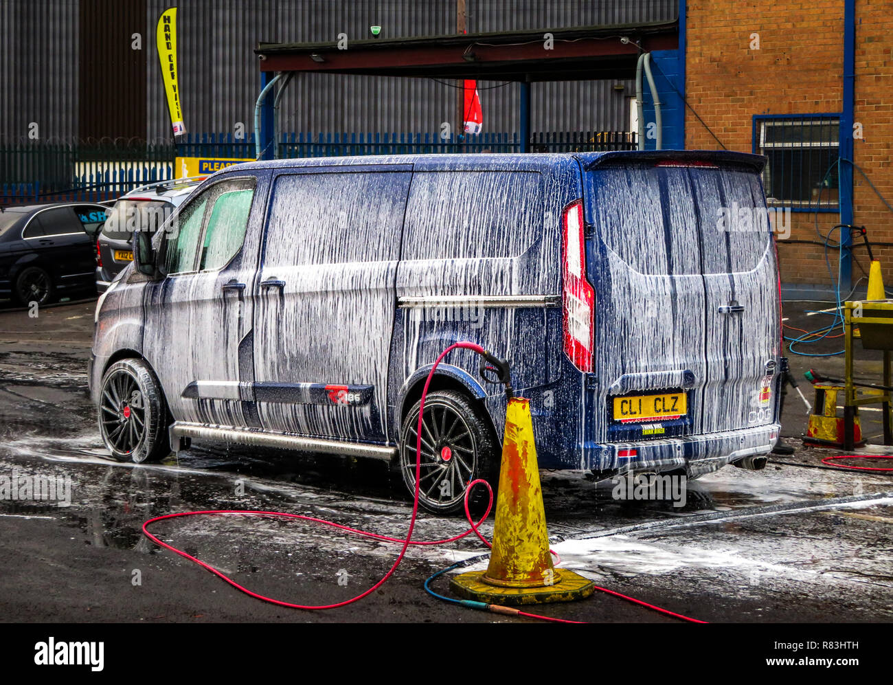 L'eau et la mousse jet pulvérisé sur un véhicule prêt à laver à la main à Rotherham, South Yorkshire, Angleterre Banque D'Images