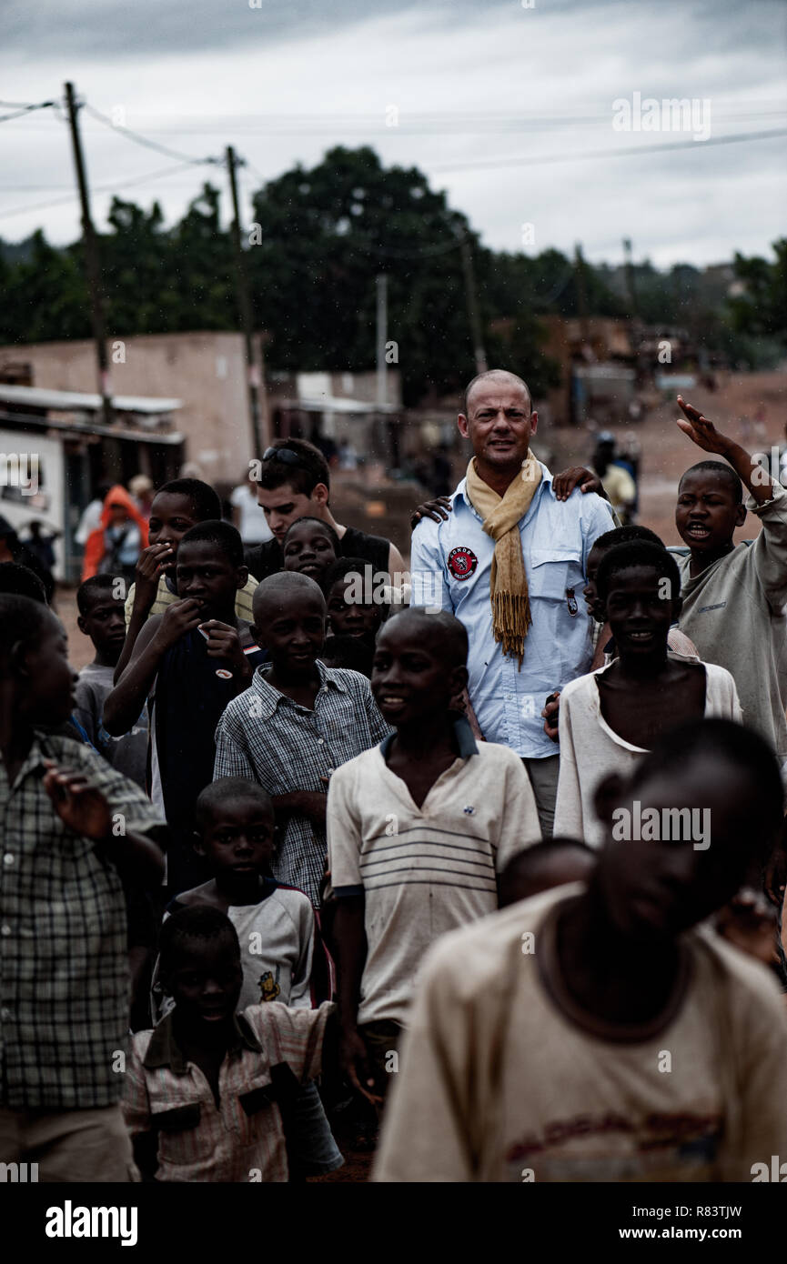 Le Mali, l'Afrique. White caucasian bénévole mature jouit d'escorter les enfants dans un village rural près de Bamako. Banque D'Images