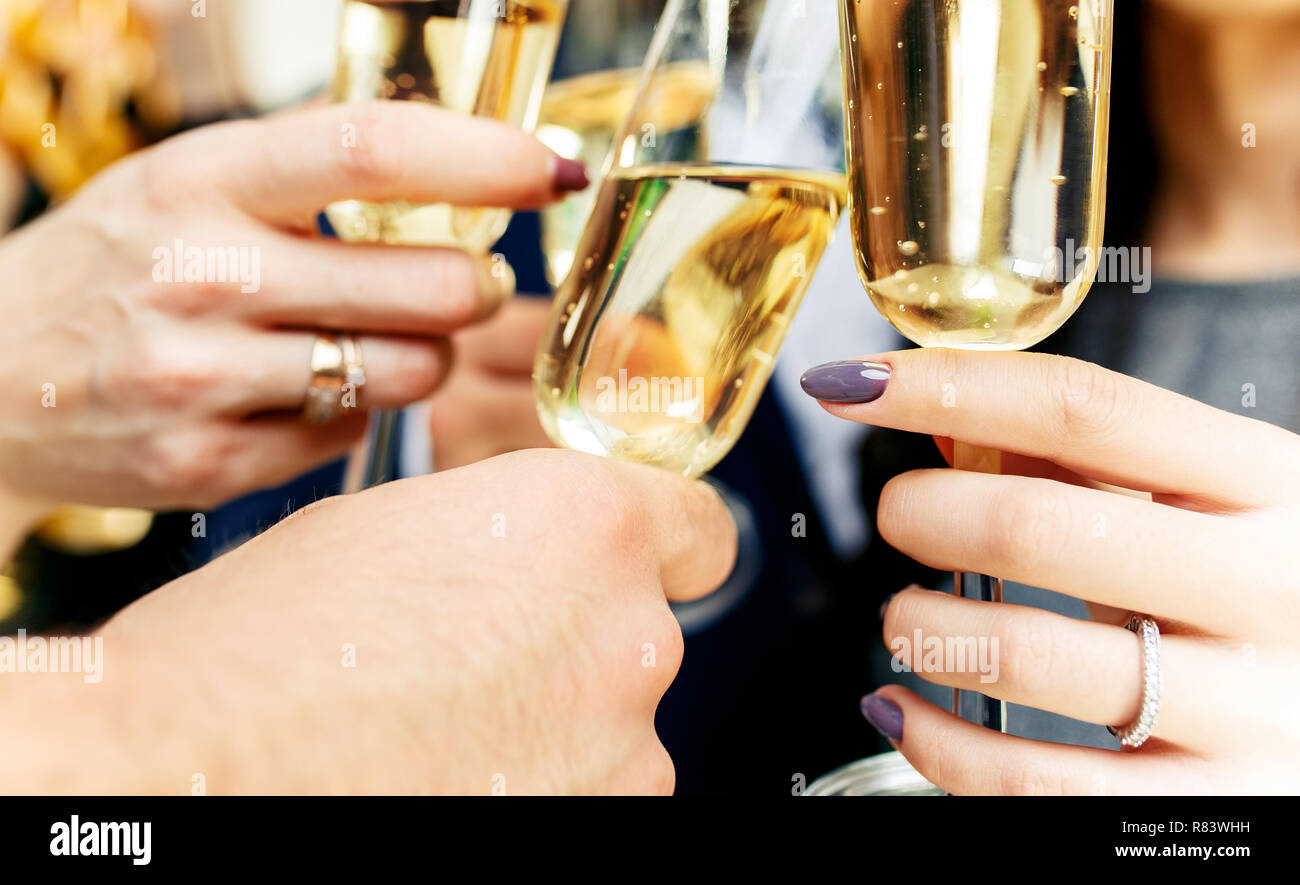 La célébration. Mains tenant les verres de champagne et vin faire un toast. Le parti, l'alcool, le mode de vie, l'amitié, maison de vacances, Noël, nouvel an, et concept de trinquer Banque D'Images