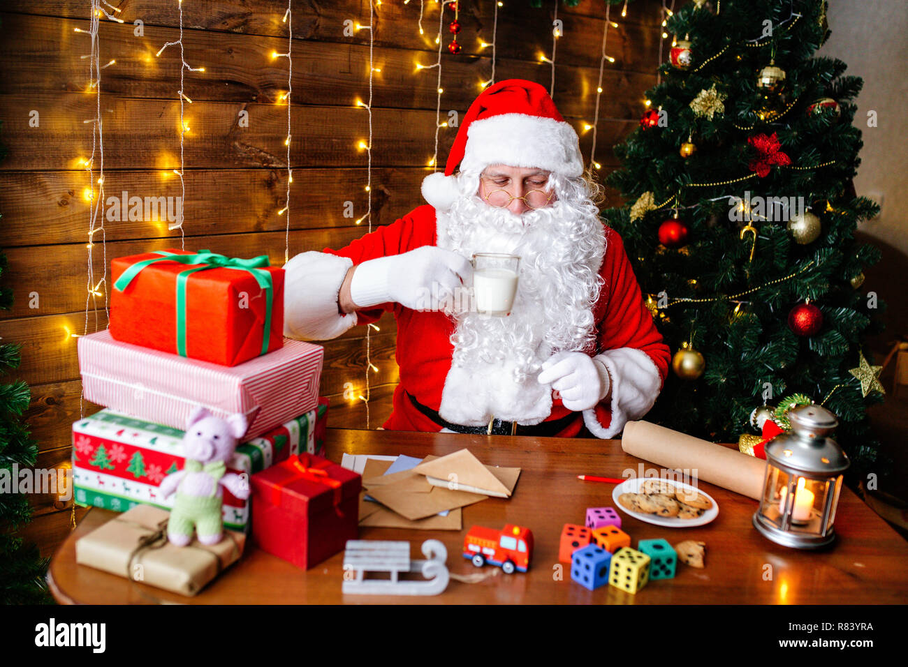 Joyeux Noël et de bonnes vacances. Le Père Noël est en train de préparer  des cadeaux pour les enfants pour Noël au bureau à la maison Photo Stock -  Alamy