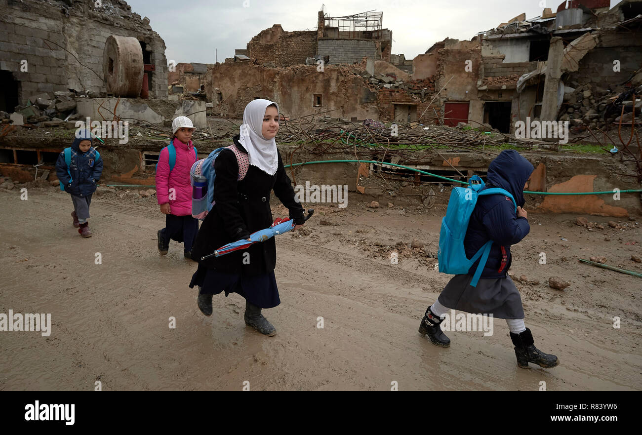 Les filles font leur chemin de l'école au milieu des décombres de la vieille ville de Mossoul, en Irak, qui a été dévastée au cours de la bataille de 2017 à Mossoul. Banque D'Images