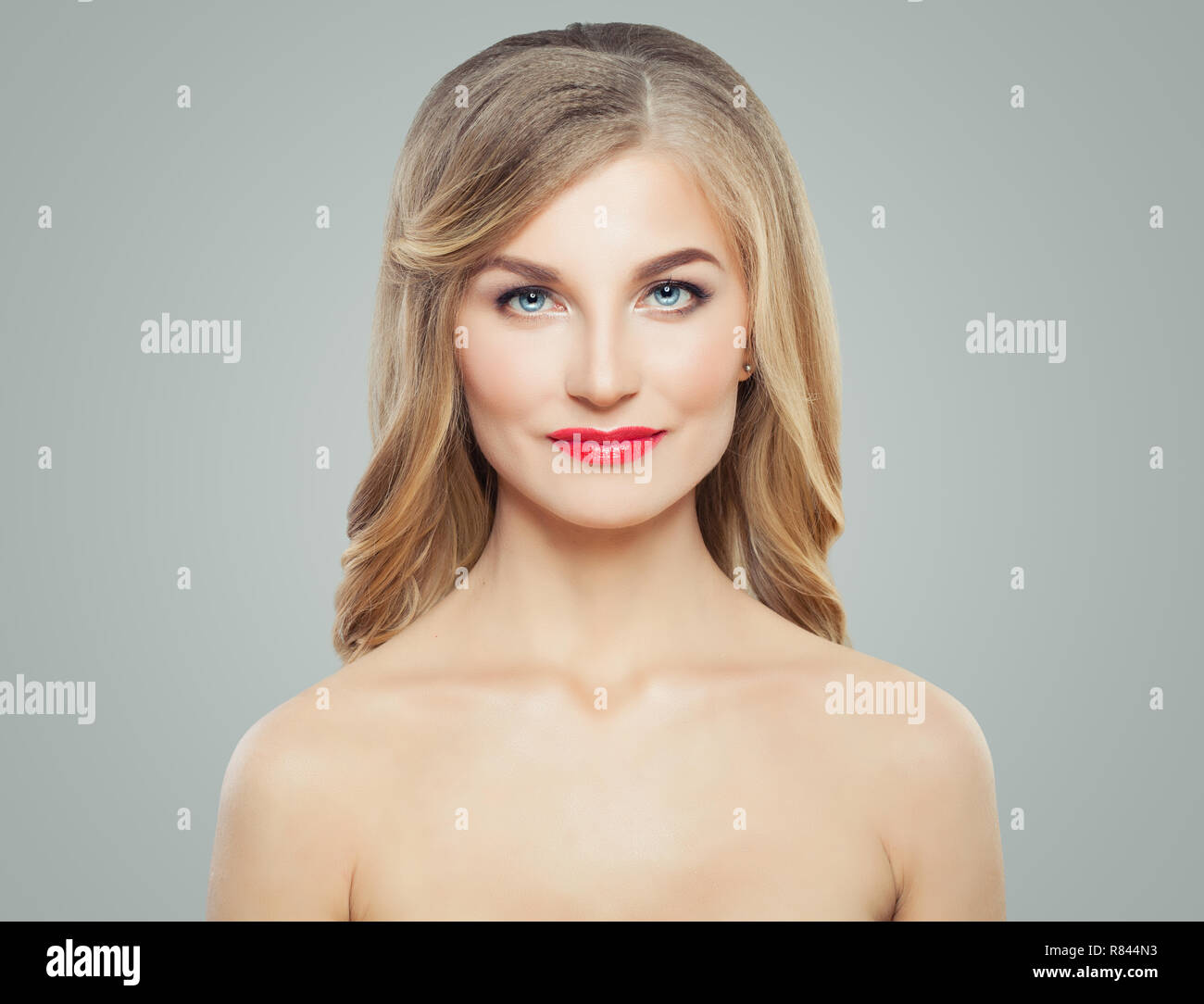Jolie femme avec de longs cheveux blonds, la peau claire et maquillage lèvres rouge. Soin du visage, soin et cosmétologie concept Banque D'Images