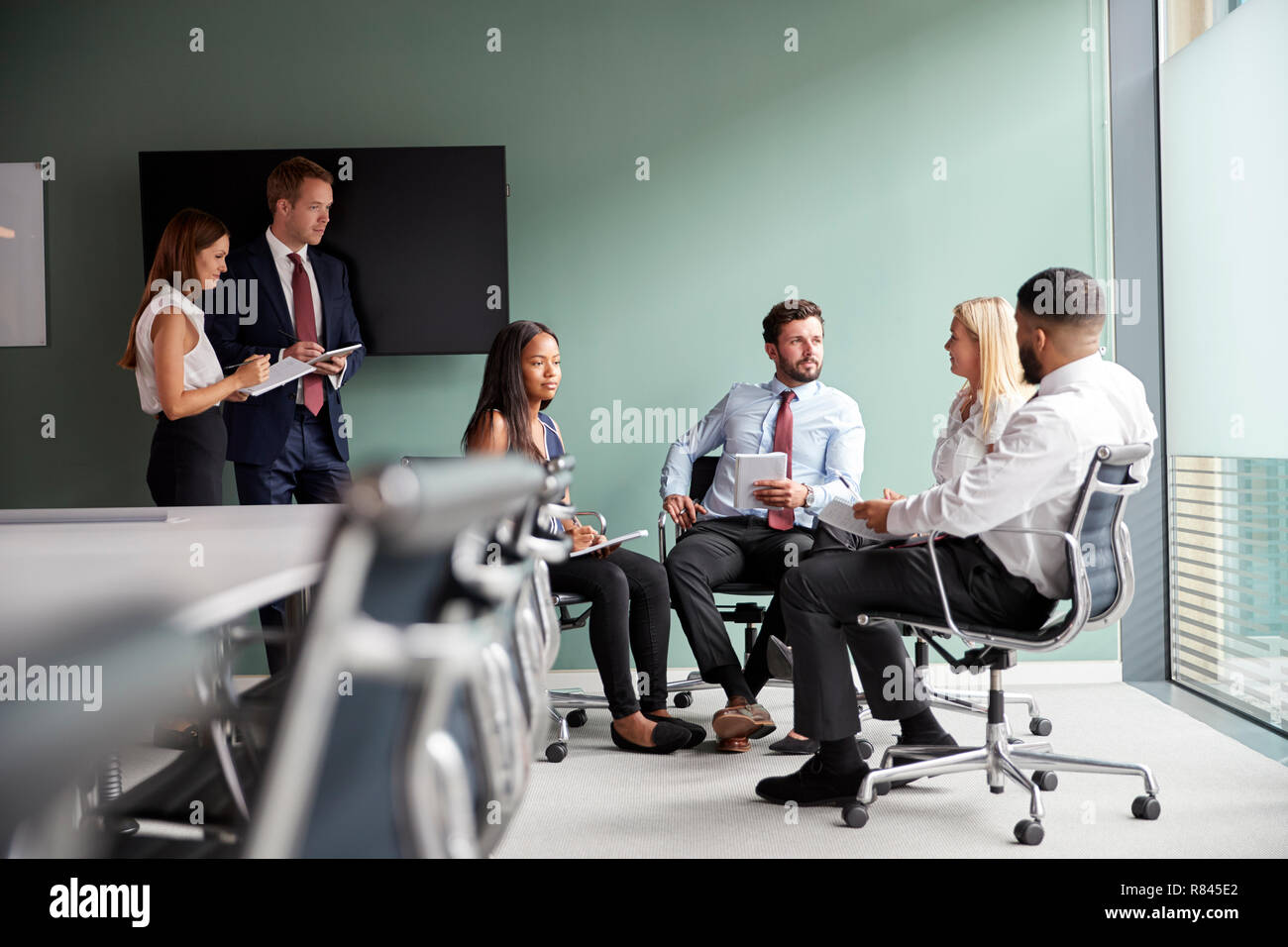 Discussion à un groupe ayant des diplômés Journée d'évaluation tout en étant observés par l'équipe de recrutement Banque D'Images