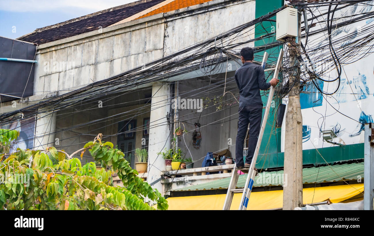 SIEM REAP, Cambodge. Electricien standing et de travail, la réparation de système de fil électrique Banque D'Images