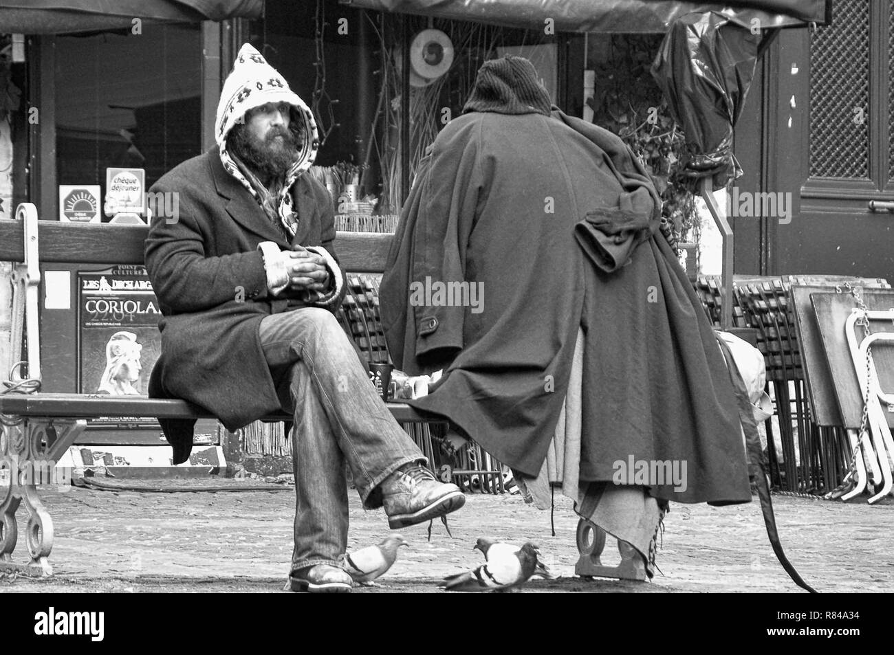Personnage excentrique avec toutes ses possessions, est assis sur un banc de la Place du marché Sainte-Catherine, le Marais, Paris, France, version noir et blanc Banque D'Images