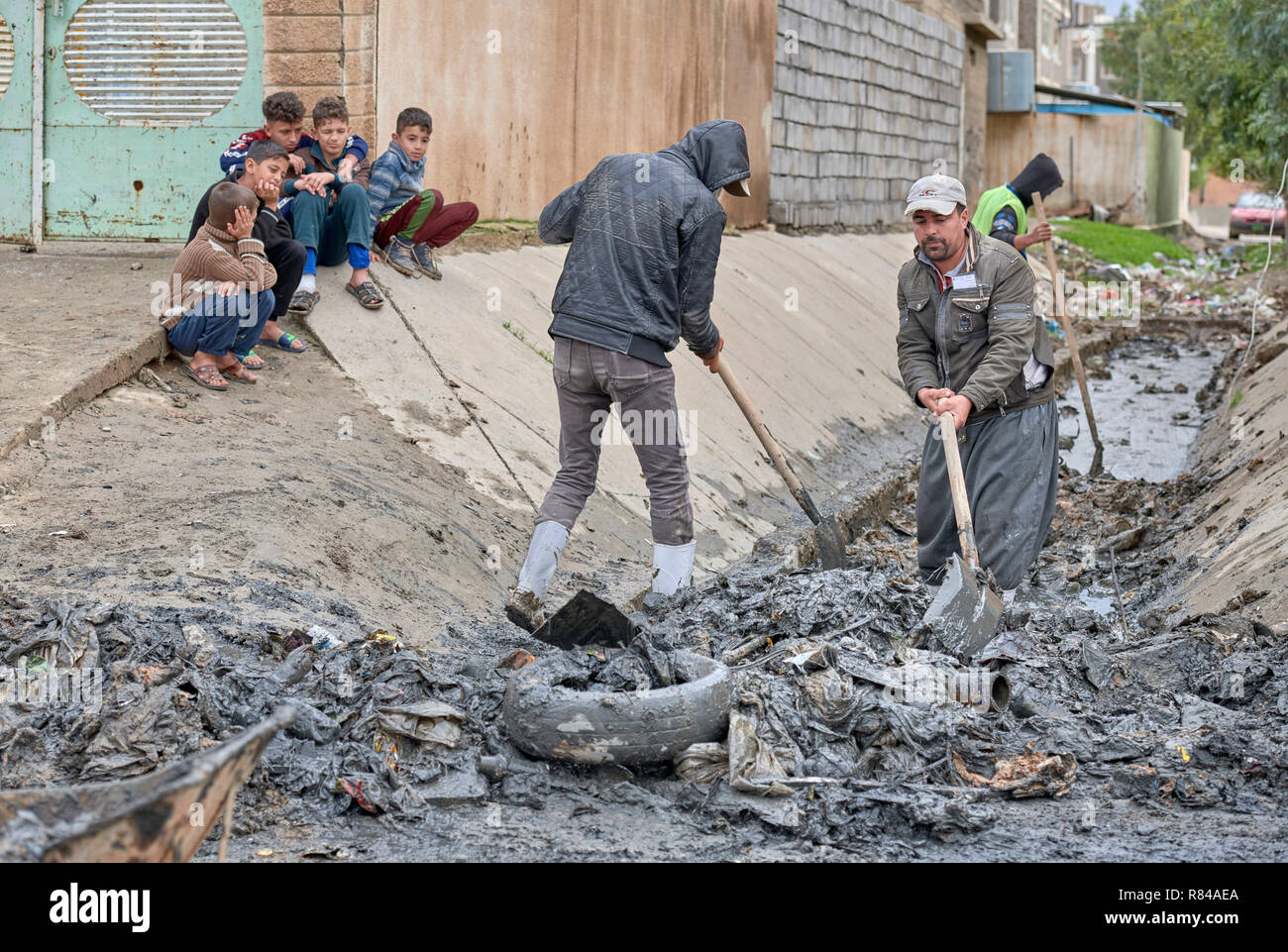 Les résidents de Mosul, Iraq, nettoyer un fossé de drainage dans la partie est de la ville. Ils participent à un programme de travail rémunéré. Banque D'Images