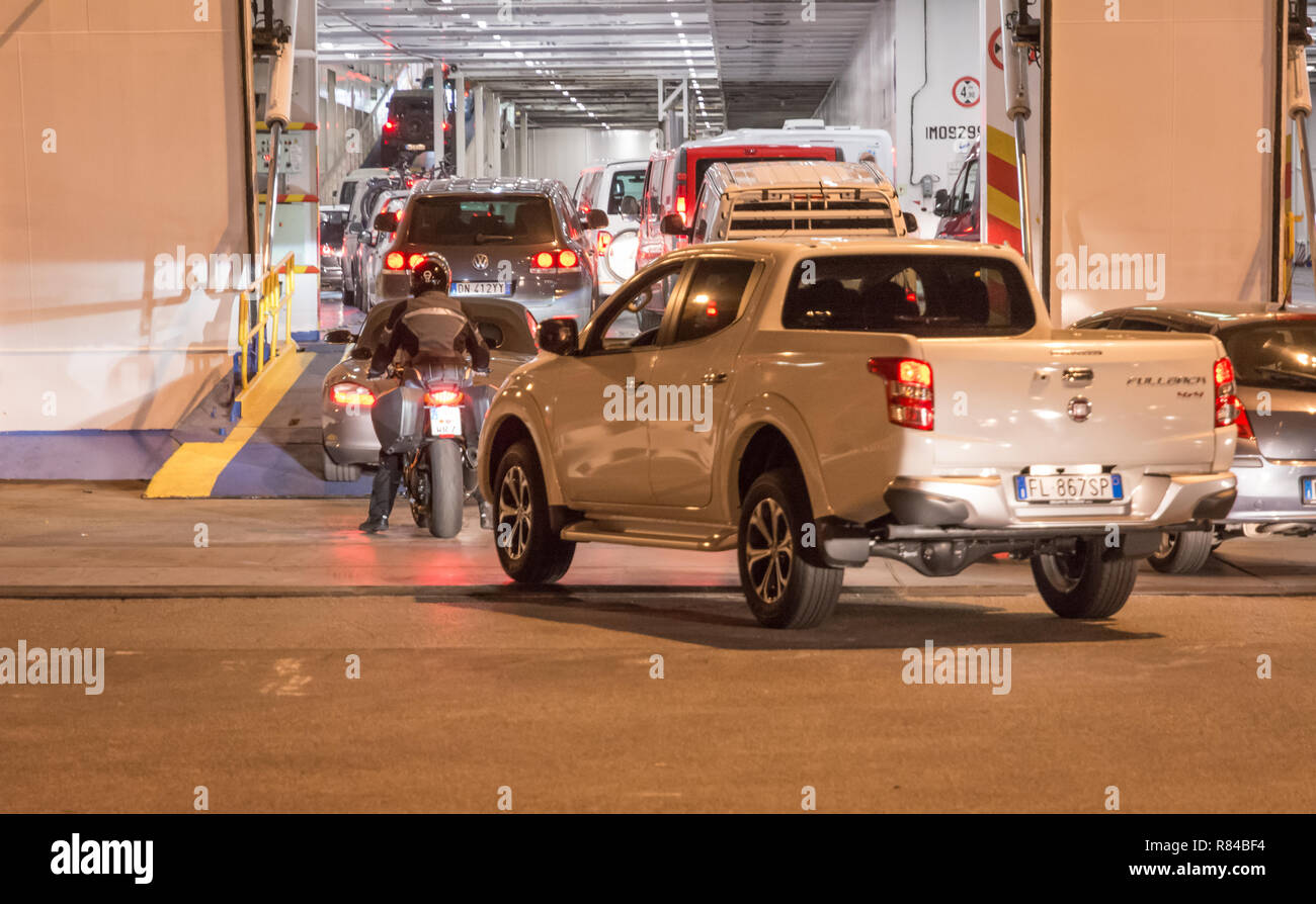 Le conseil et les motocyclistes véhicules Moby Line ferry pour l'île de la Sardaigne, en Italie, à partir du port de Livourne. Banque D'Images