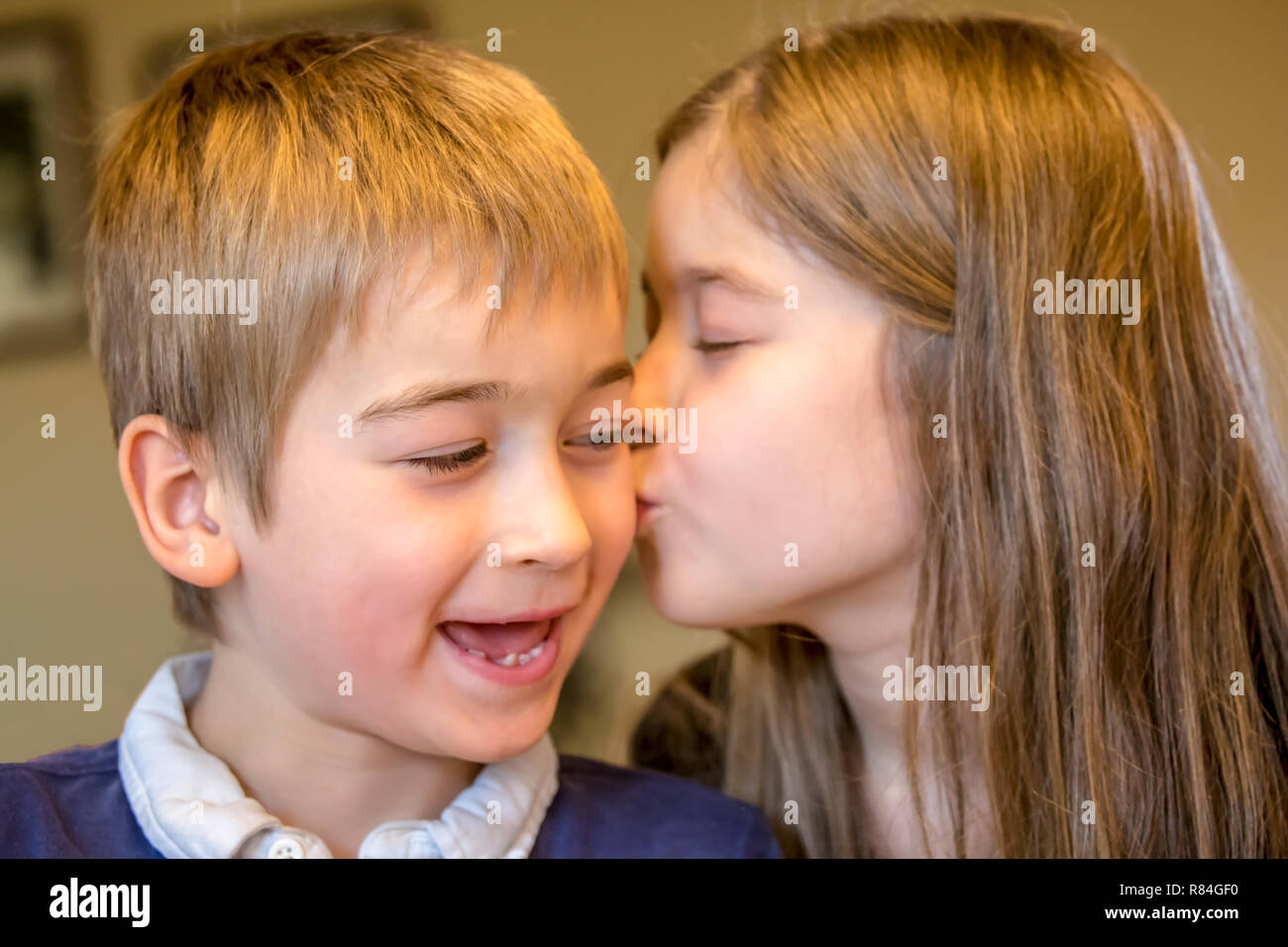 Neuf ans, fille de l'embrasser de 7 ans frère pour son anniversaire. (MR) Banque D'Images