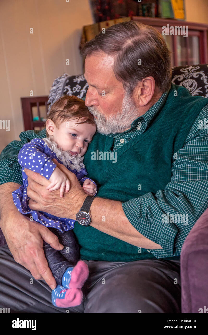 Grand-père tendrement tenant sa petite fille, âgée de trois mois. (MR) Banque D'Images