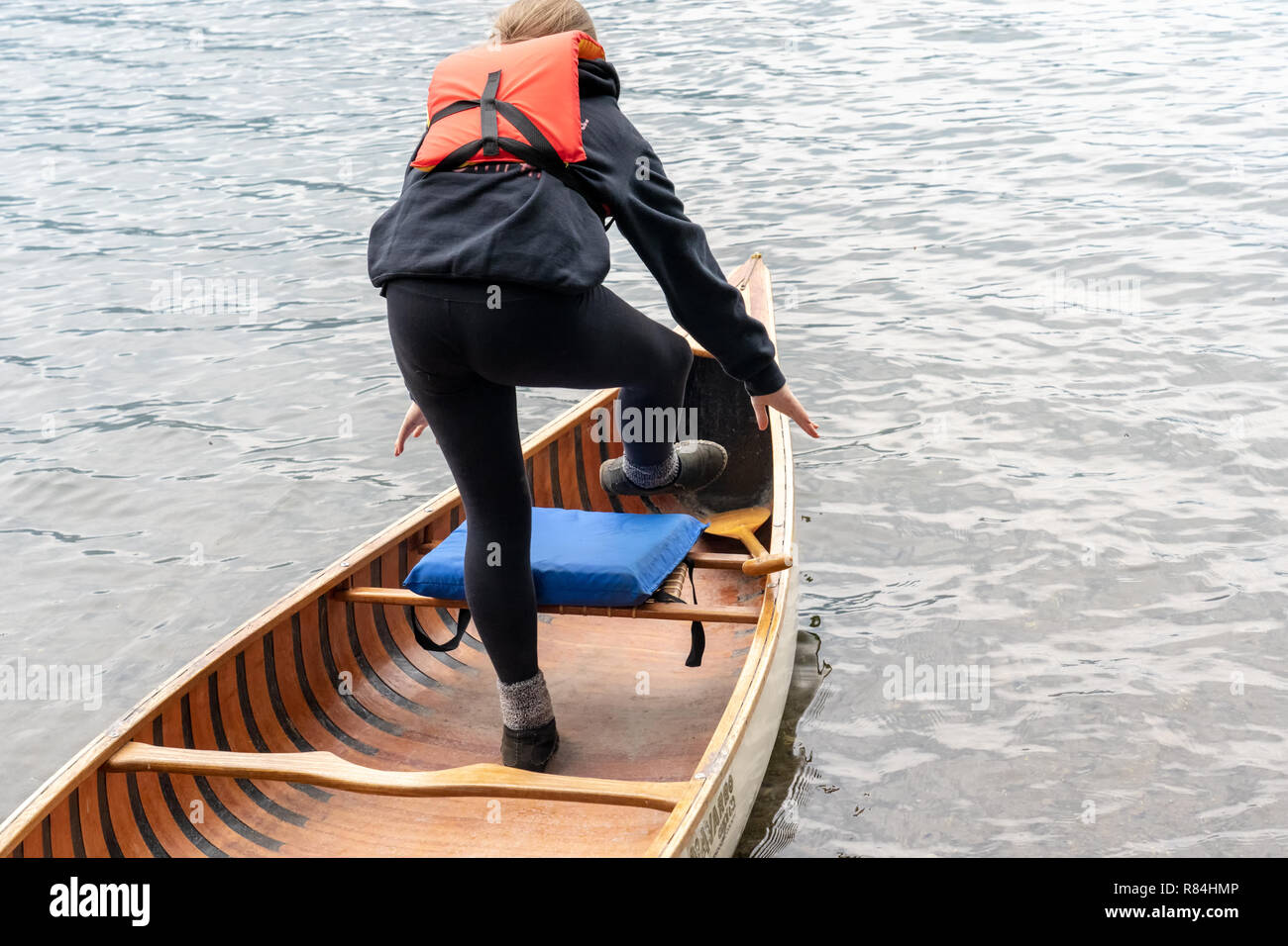 Lake Easton State Park, Washington, USA. 12 ans, fille, comme elle l'équilibrage entre dans le siège avant d'un canot dans Lake Easton. (MR) Banque D'Images