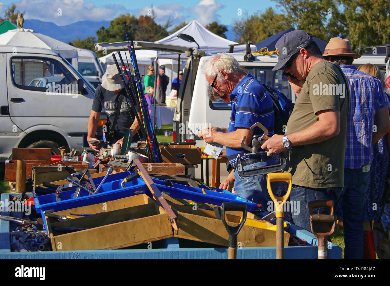 L'homme l'utilisateur de l'outil. Les hommes l'achat d'outils à un décrochage du marché en plein air en Nouvelle Zélande Banque D'Images
