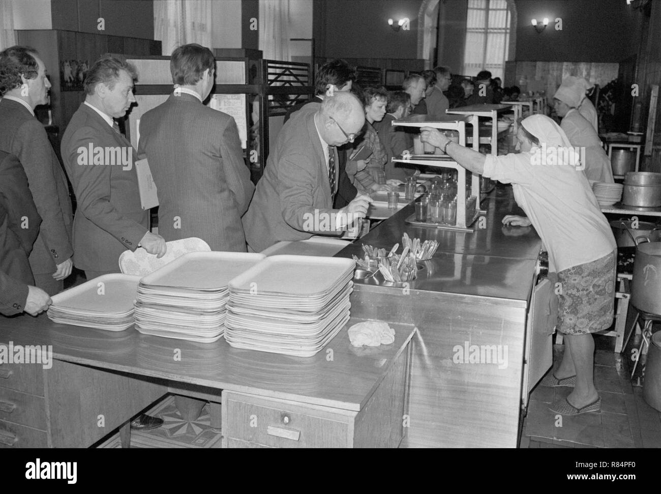 Moscou, URSS - 23 novembre 1989 : cantine dans le ministère de l'industrie automobile de l'URSS. Employés la queue pour obtenir des repas. Les travailleurs de cantine servir les aliments. Banque D'Images