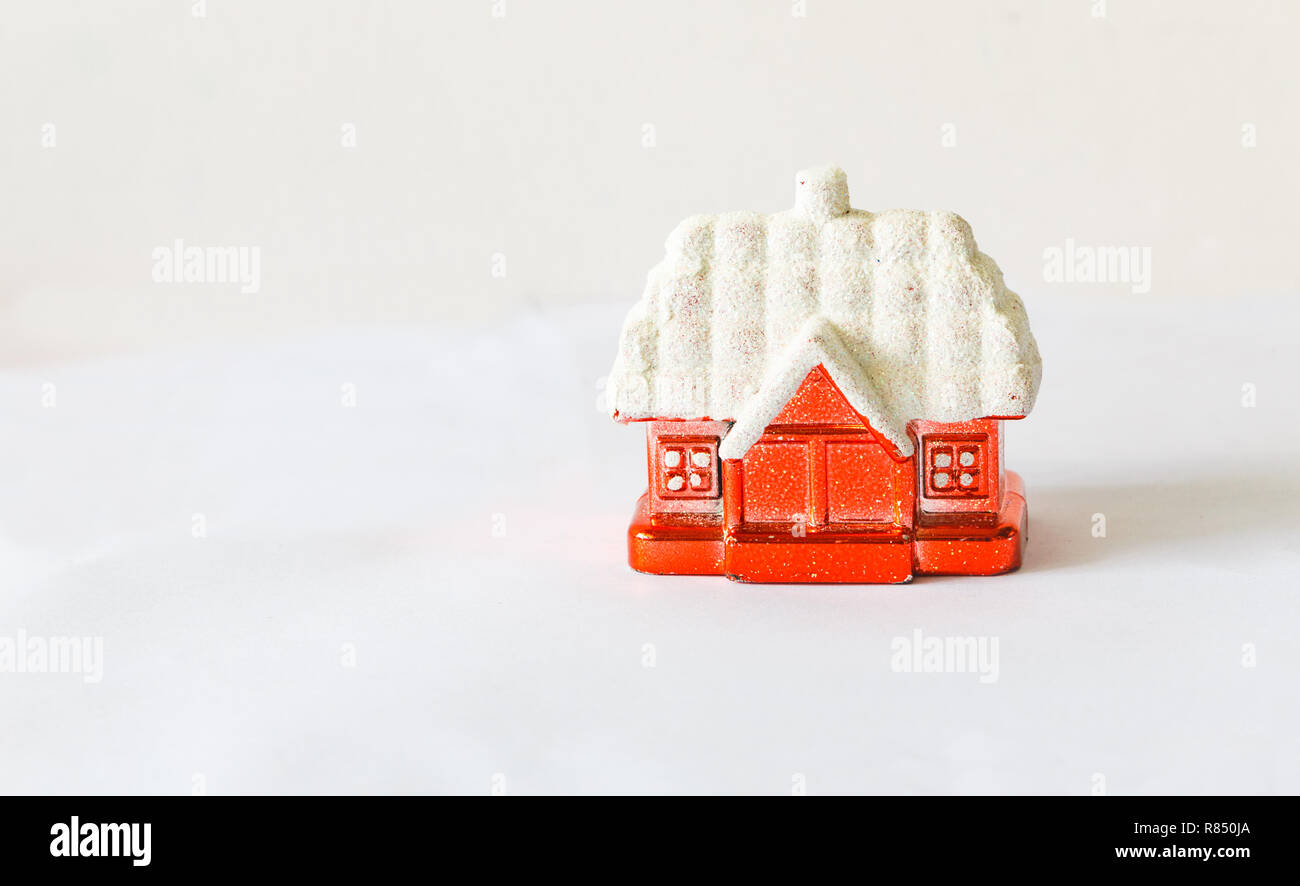 Nouvelle Année. décoration chambre rouge avec un toit recouvert de neige sur un fond blanc. Banque D'Images