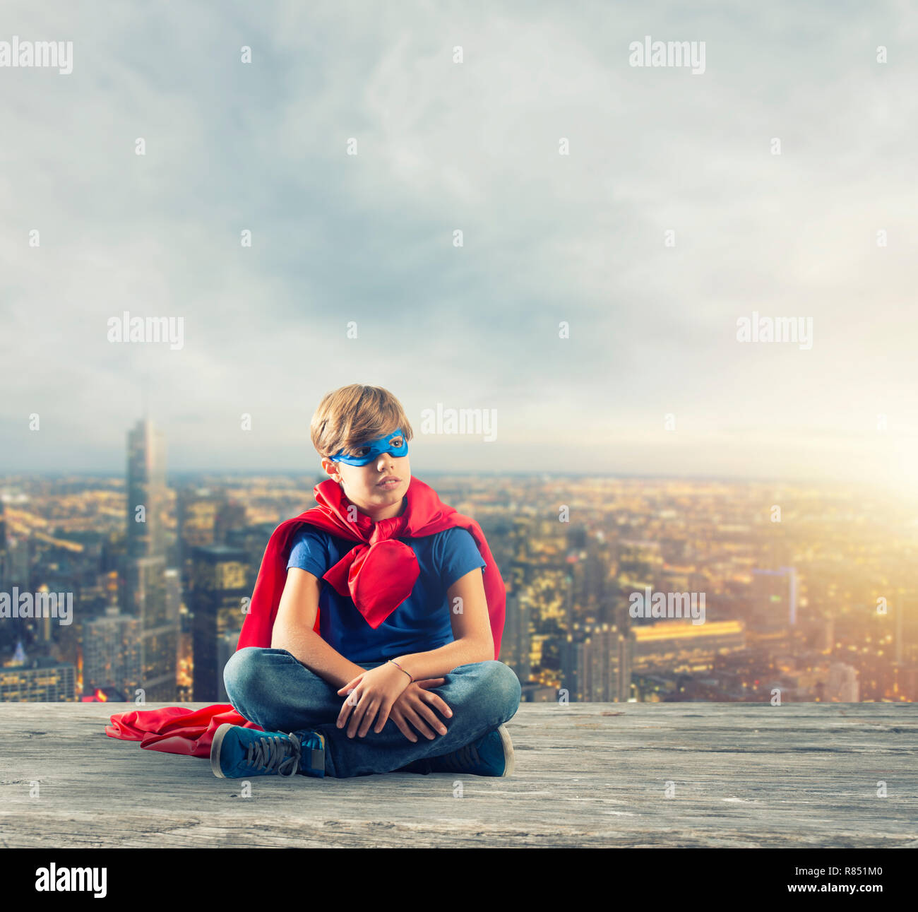 Super Héros kid assis sur un mur que les rêves Banque D'Images