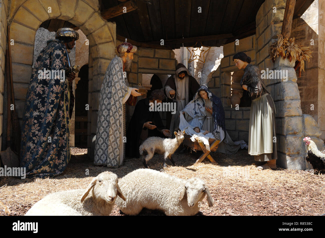 Naissance de Jésus à Bethléem, le Jour de Noël avec trois sages en plein robes portant des cadeaux pour bébé en crèche près de Marie et Joseph en moutons stable. Banque D'Images