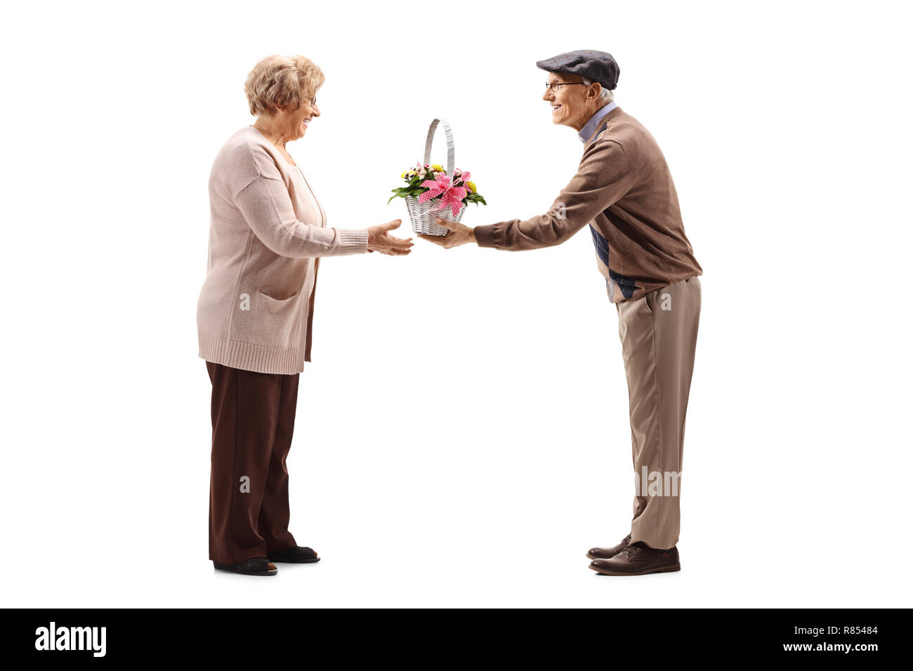 Longueur totale d'un couple mignon d'un homme donnant des fleurs à une femme isolée sur fond blanc Banque D'Images