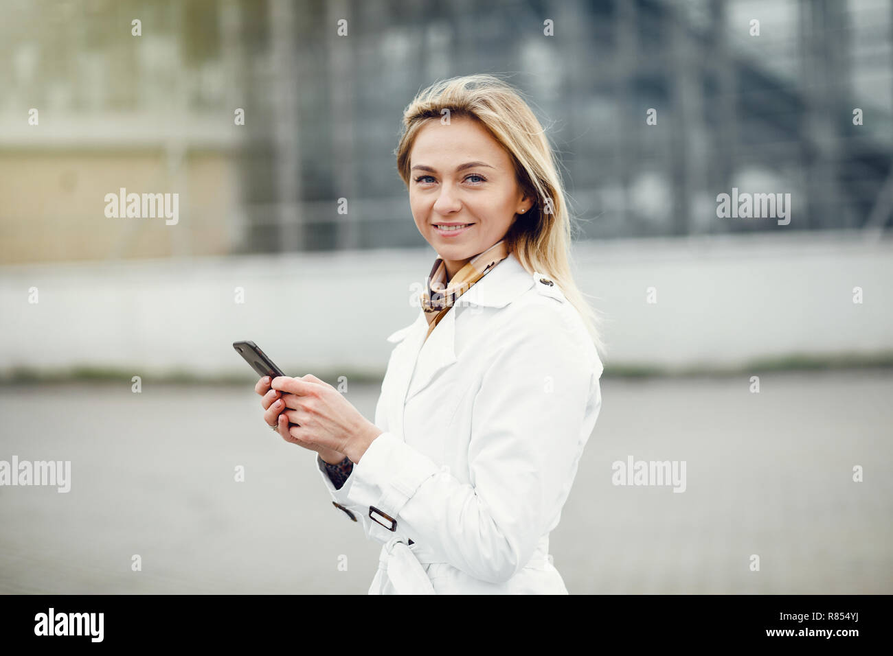 Jolie jeune femme élégante posant dans les rues de la ville et de l'utilisation Banque D'Images