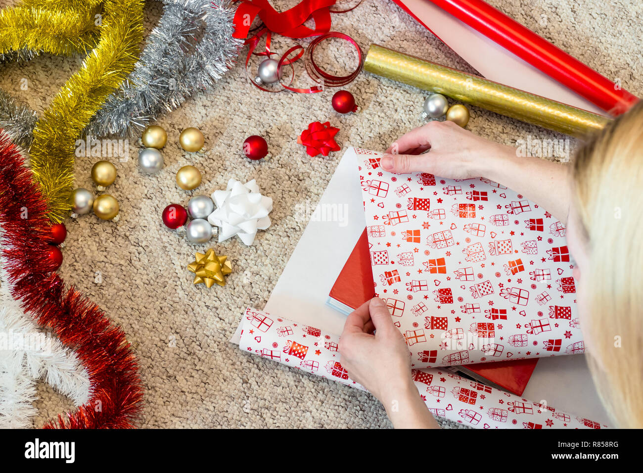 Woman wrapping Christmas present avec matériaux colorés Banque D'Images