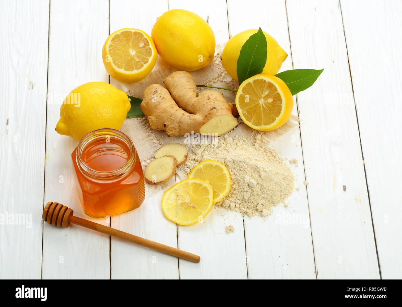 Racine de gingembre, citron et miel sur fond de bois blanc Banque D'Images