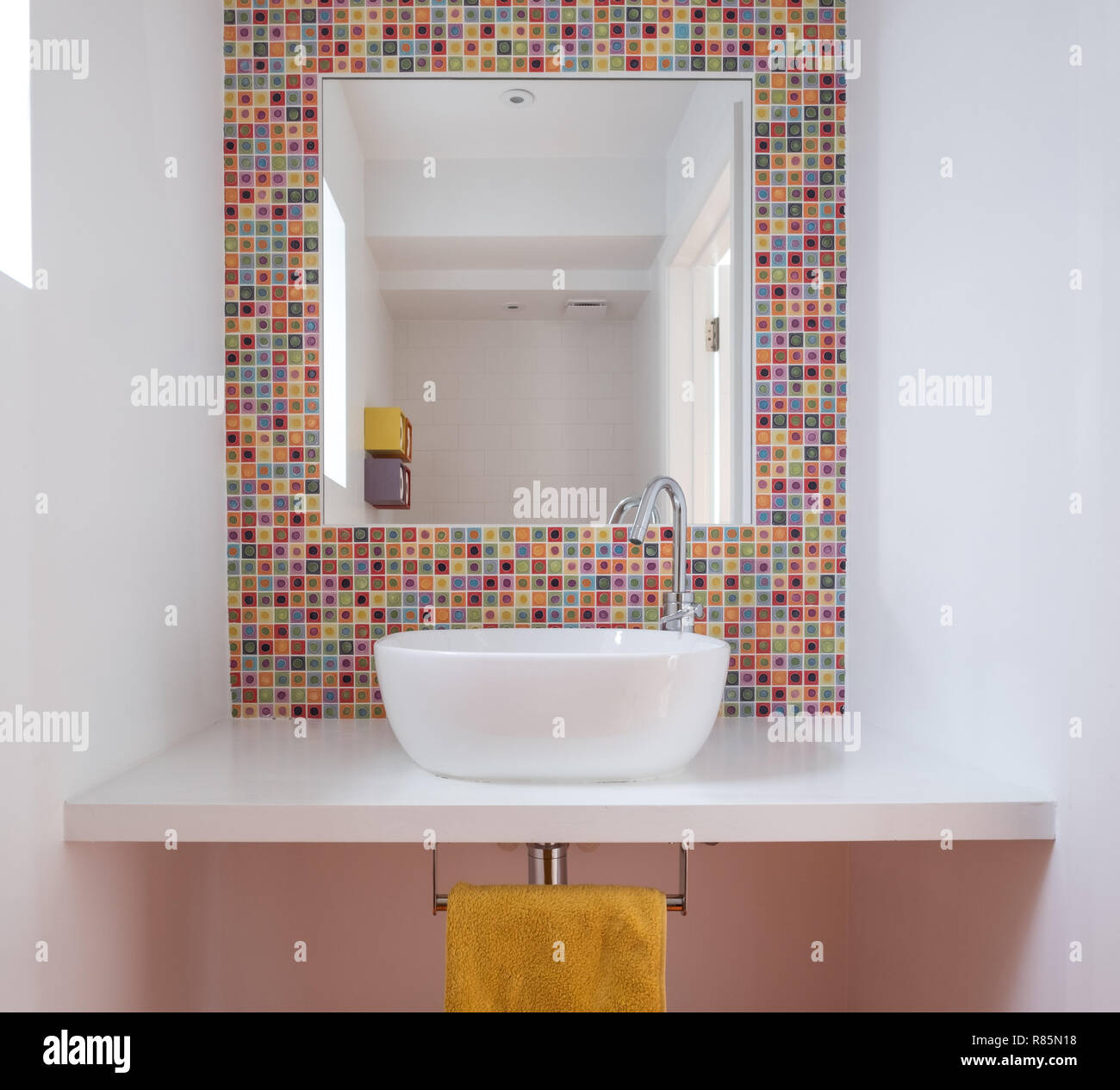 Salle de bain moderne avec lavabo, carreaux en pâte de verre coloré,  plateau MDF peint et miroir encadré dans les tuiles Photo Stock - Alamy
