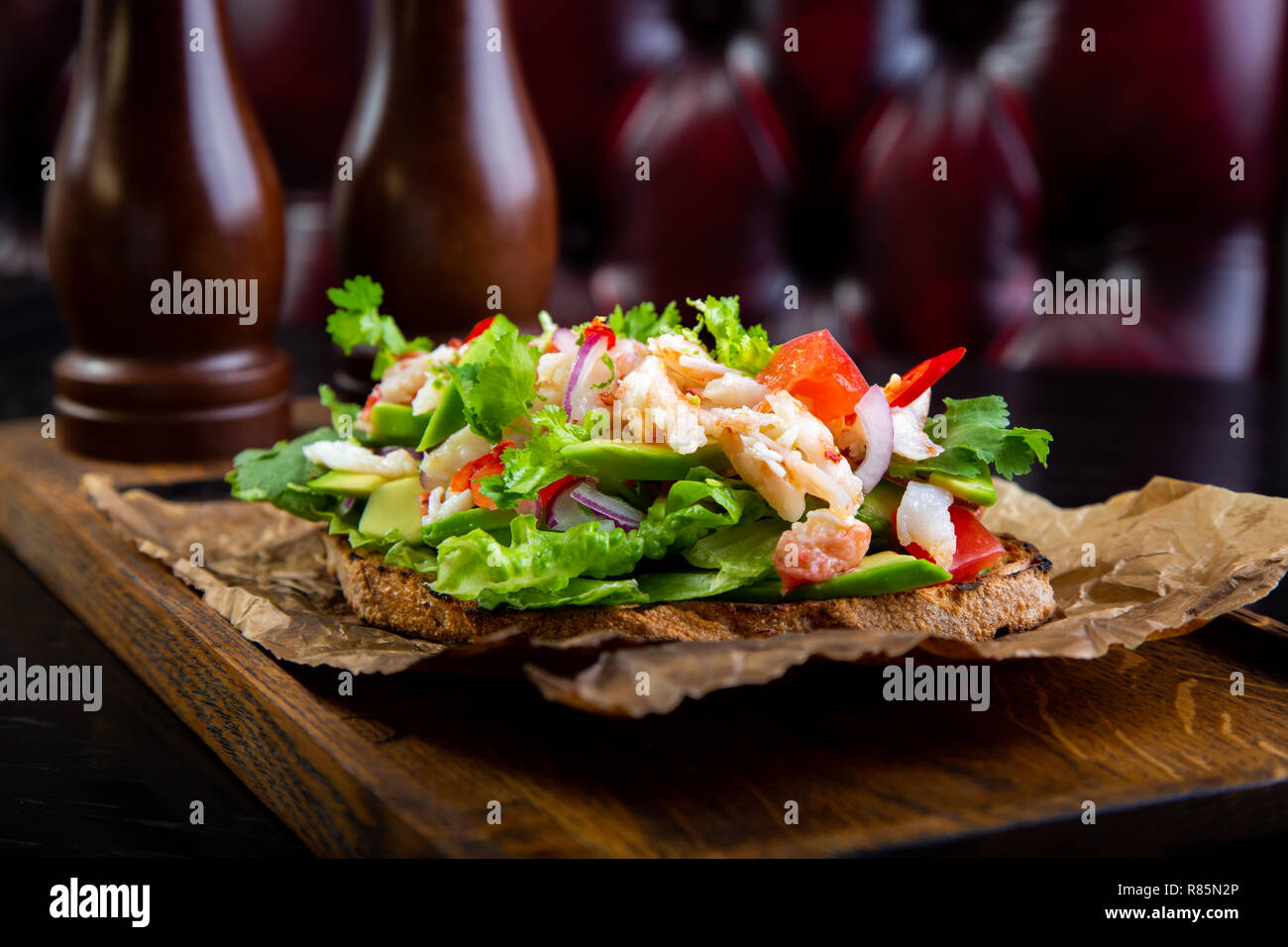 Bruschetta délicieux à la viande de crabe dans le fond. Nourriture exclusive sain servi sur une planche en bois et papier d'artisanat Banque D'Images