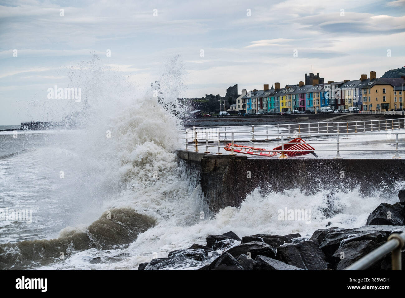 Aberystwyth, Pays de Galles. 13 décembre 2018. Météo France : forts coups de vent et une marée haute se combinent pour hammer énormes vagues contre les défenses de la mer à Aberystwyth, sur la côte ouest de la Baie de Cardigan au Pays de Galles. Un froid glacial vent souffle avec des rafales atteignant 36 km/h, et une prévision de gel la nuit comme le ciel clair crédit photo Keith Morris / Alamy Live News Banque D'Images