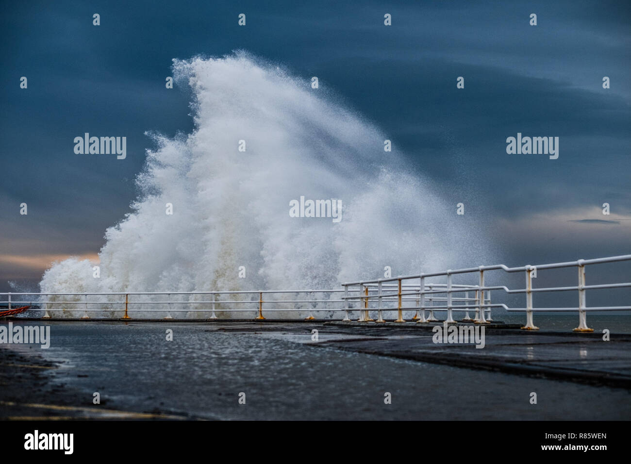 Aberystwyth, Pays de Galles. 13 décembre 2018. Météo France : forts coups de vent et une marée haute se combinent pour hammer énormes vagues contre les défenses de la mer à Aberystwyth, sur la côte ouest de la Baie de Cardigan au Pays de Galles. Un froid glacial vent souffle avec des rafales atteignant 36 km/h, et une prévision de gel la nuit comme le ciel clair crédit photo Keith Morris / Alamy Live News Banque D'Images