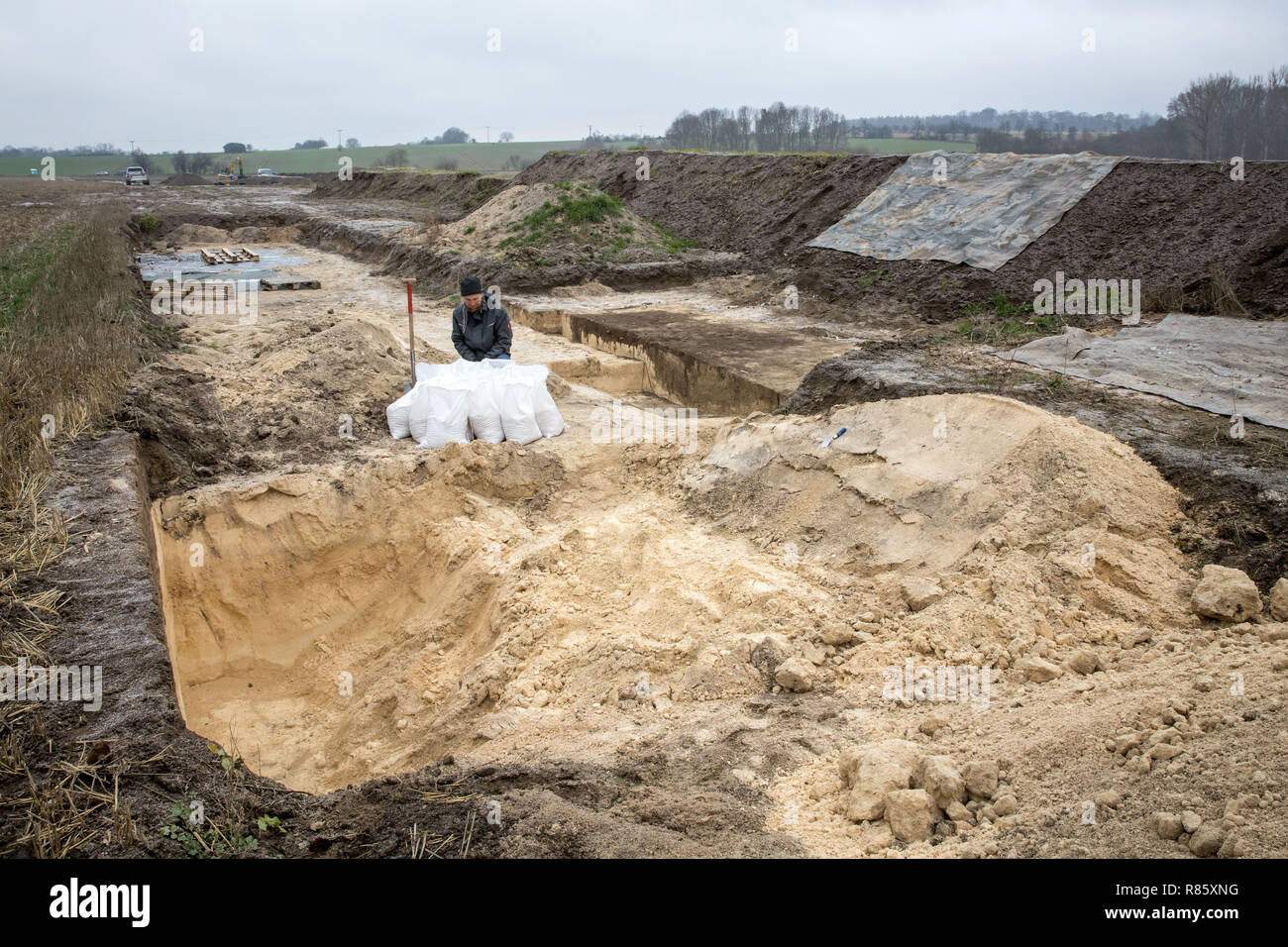 13 décembre 2018, la Thuringe, Mühlhausen : Christian Tannhäuser de l'Office d'état de Thuringe pour la préservation des monuments et archéologie travaille dans la gestion de l'excavation archéologique pour la nouvelle dérivation Reiser près de Mühlhausen. Au cours des fouilles, spectaculaire colonie romaine trouve ont été découvertes, y compris la qualité et la poterie peinte, d'innombrables groupes d'avis et, pour la première fois en Thuringe, preuve de l'artisanat en métal romain. Photo : Arifoto Ug/Michael Reichel/dpa Banque D'Images