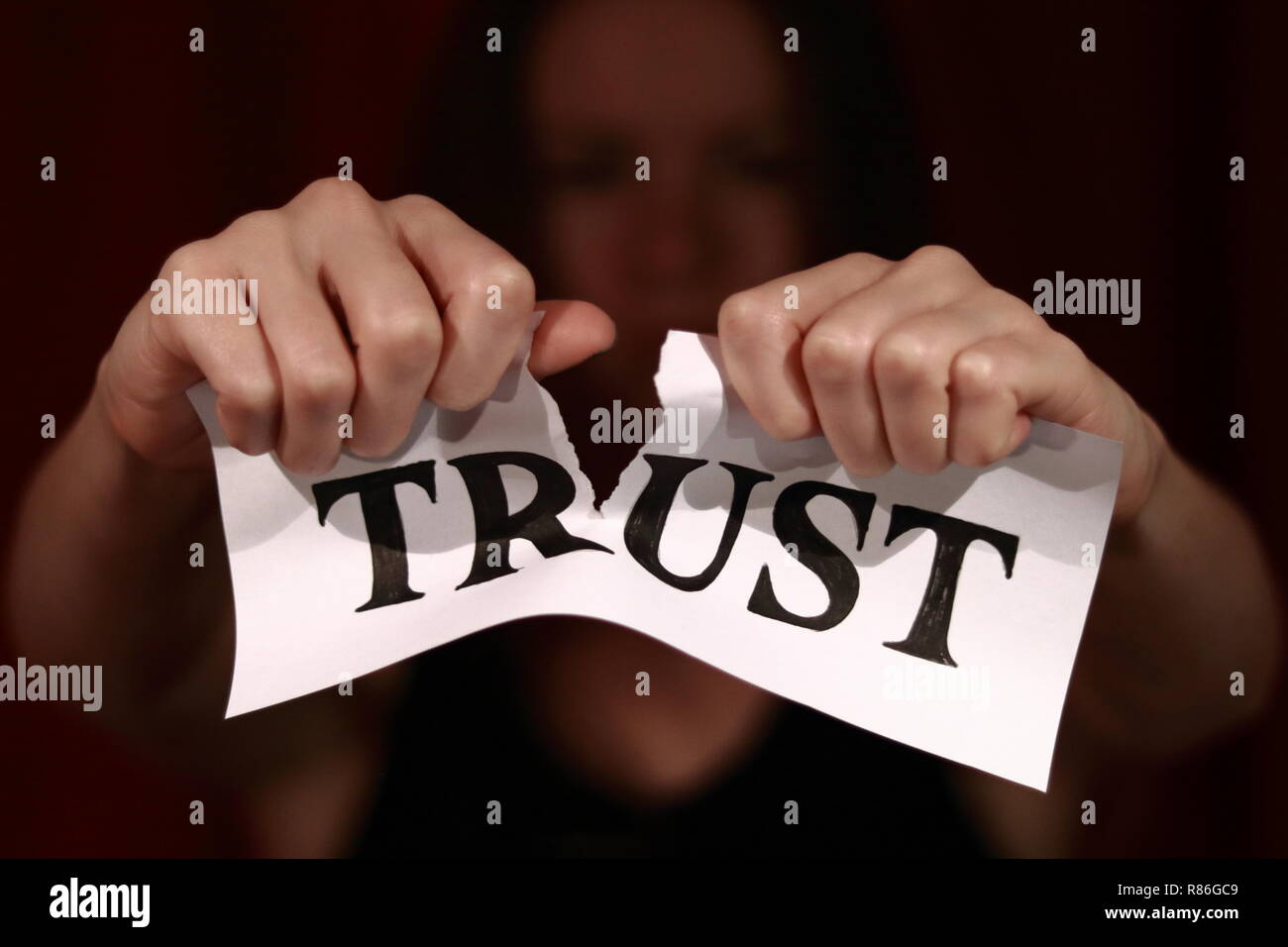 Déchiré du papier blanc avec des lettres tirées de 'trust' sur elle. L'extraction de fille de papier en deux moitié. Banque D'Images