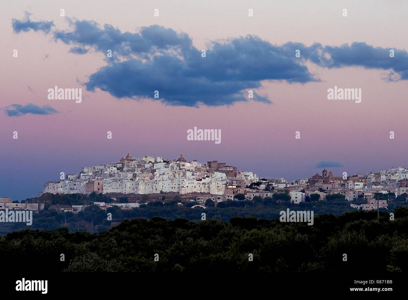 La pittoresque vieille ville d'Ostuni, dans le sud de l'Italie dans l'incandescence de rose au coucher du soleil. Banque D'Images