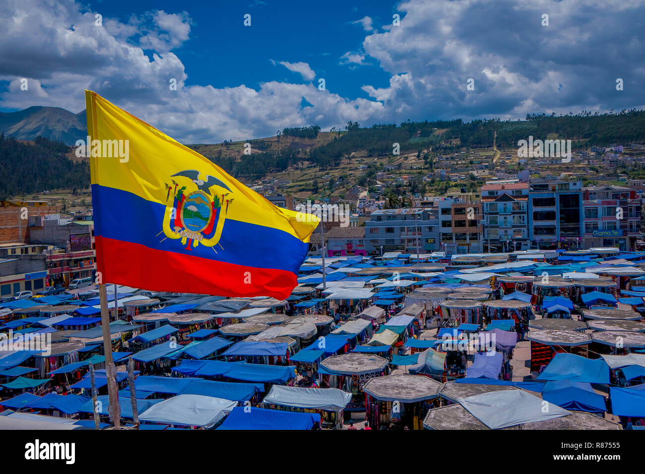 OTAVALO, ÉQUATEUR, 06 novembre 2018 : beaux drapeaux flottant équatorienne dans une magnifique journée ensoleillée avec abris situé dans la rue market à Otavalo avec une montagne derrière à Otavalo Banque D'Images