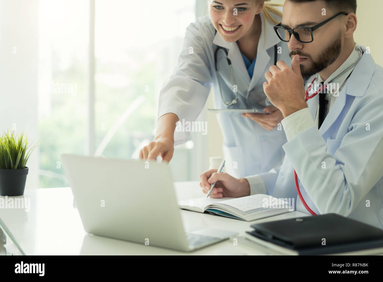 Deux médecins l'analyse et de consultation sur dossier médical de l'hôpital moderne. Les médecins de race blanche parle de rapport. Banque D'Images