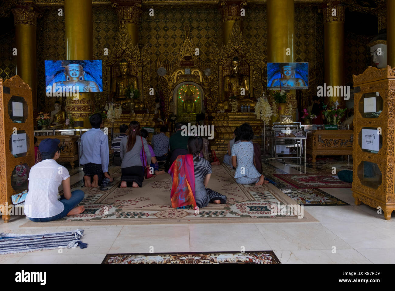 Une prière à la grande pagode Shwedagon à Yangon, Myanmar. Banque D'Images