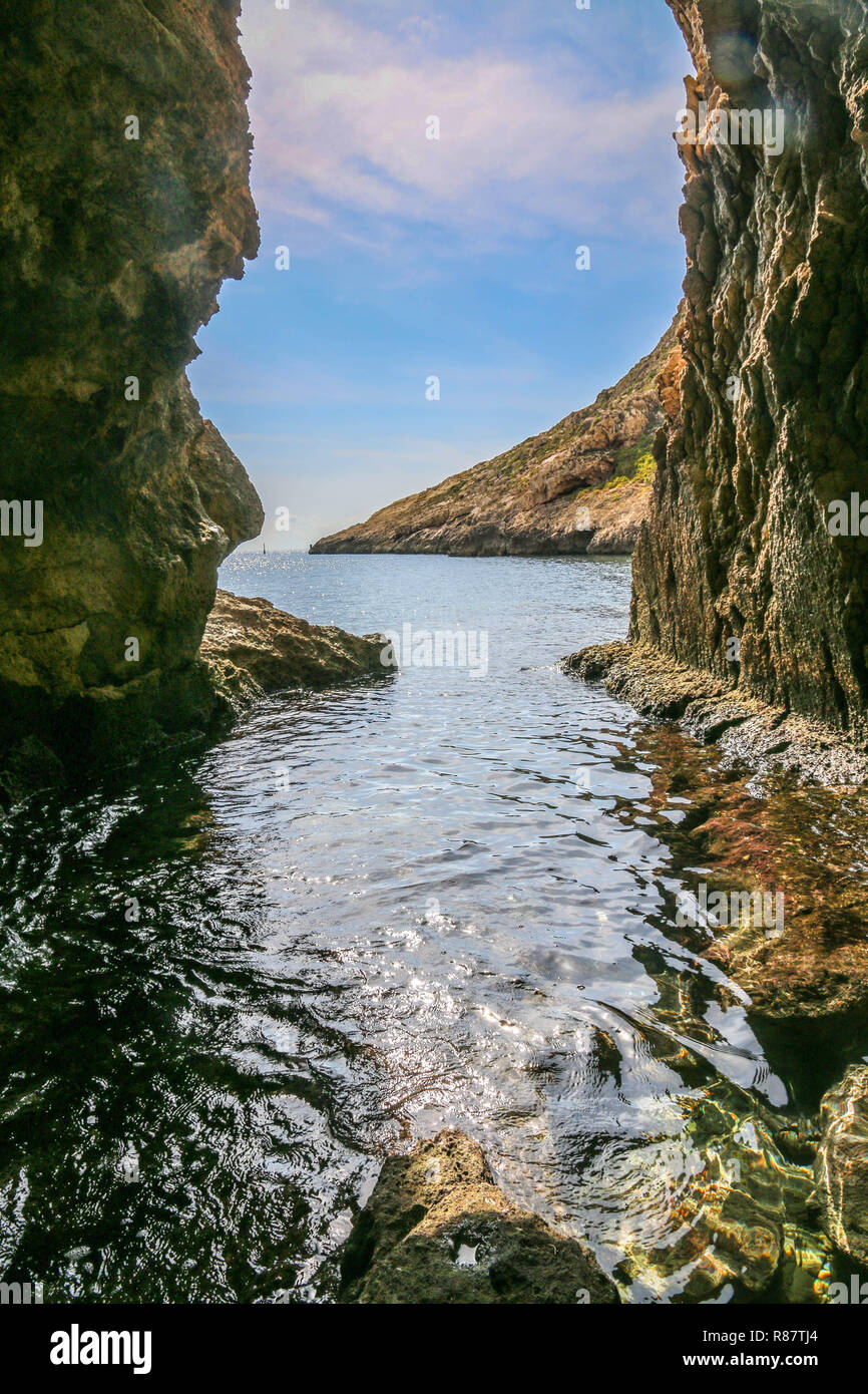 Xlendi, Gozo, Malte - grotte cachée dans la montagne avec une vue sur la mer. Banque D'Images