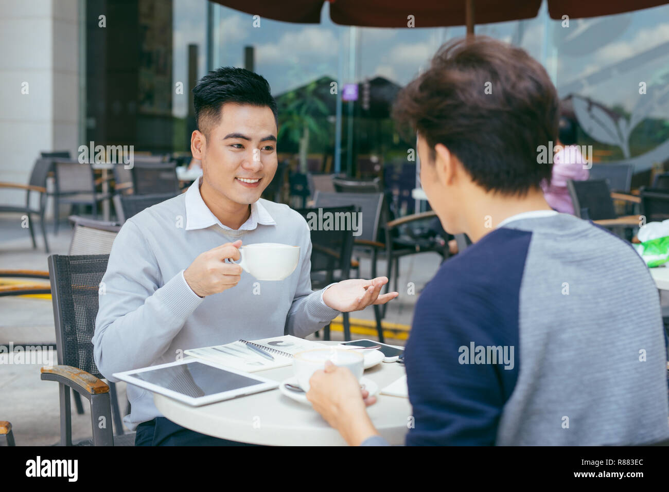 Contrôler les stocks. Deux partenaires travaillant sur l'ordinateur portable en souriant gaiement sur une réunion au café local - Image Banque D'Images