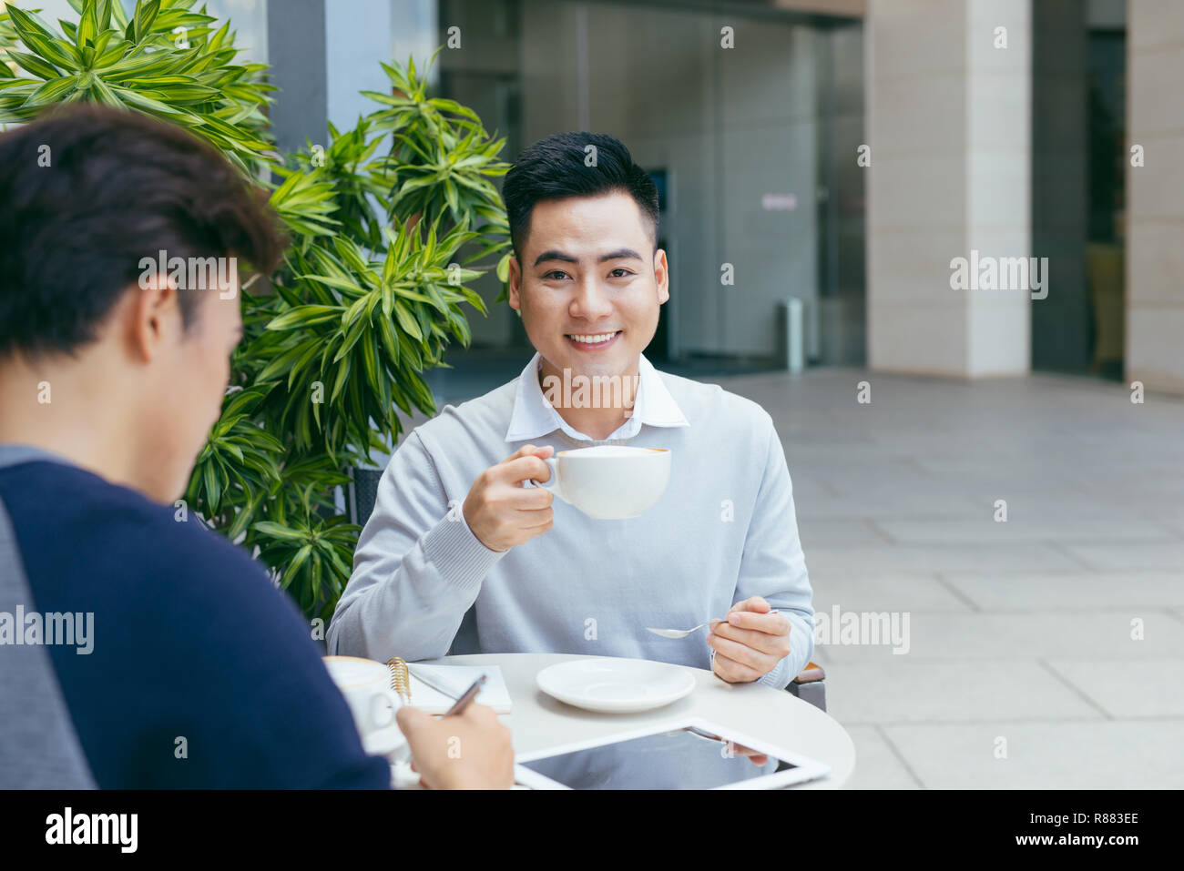 Les gens d'affaires à la recherche de document et discuter tout en café. Deux hommes d'affaires travaillent ensemble à business report du coffee shop. - Image Banque D'Images
